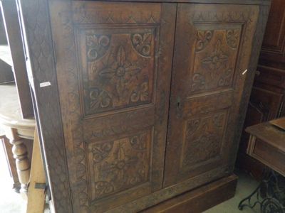 a large wooden cabinet with carvings on the doors