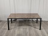 La table est en bois et en métal, avec un plateau en marbre.