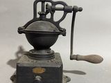 an old coffee grinder sitting on top of a table