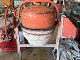 une bétonnière rangée dans un garage avec d'autres outils