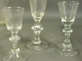 four wine glasses sitting next to a pitcher on a table