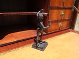 une statue en bronze représentant un garçon sur un socle