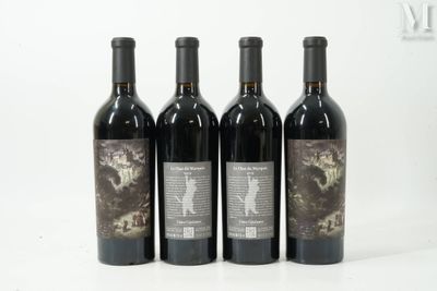 quatre bouteilles de vin sont alignées sur une surface blanche
