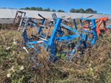 une charrue bleue qui est posée dans l'herbe