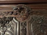 a close up of a carved wood door with a bird on it