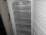 a white refrigerator with its door open next to a wall