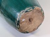 a green vase that has a hole in it