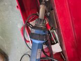 a red tool box with tools in it and a person standing next to it