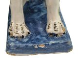 a figurine of a dog that is sitting on a blue mat