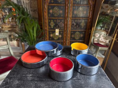 four tins of paint sitting on top of a wooden table