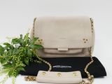 a white purse and a plant on a black cloth