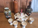 de nombreuses tasses et soucoupes posées sur une table, à côté d'une bouteille