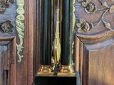 a clock sitting on a table in front of a wooden paneled wall