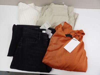 three pairs of black, orange, and white pants on a table
