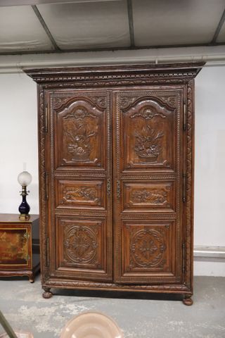Belle armoire en chêne sculpté de bouquet de fleur et cornes d’ab...