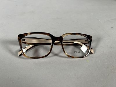 une paire de lunettes posée sur une table, sur fond blanc
