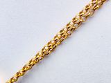 a close up of a gold chain bracelet with a heart charm on it