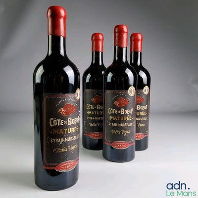 trois bouteilles de vin posées sur une table l'une à côté de l'autre