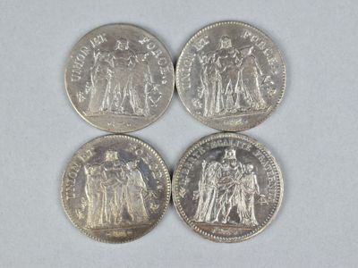 four different types of silver coins on a white surface