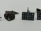 trois paires de boutons de manchette posées sur une table