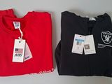 deux t-shirts avec leurs étiquettes, posés sur une table