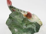 a figurine of a bird on a green leaf