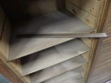 a wooden cabinet that has a bunch of paper on it