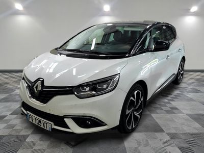 la voiture blanche est garée sur un sol en damier dans le garage