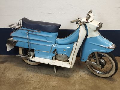 a blue and white motor scooter parked next to a wall