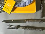 a plate with a fork, knife, and spoon on a table