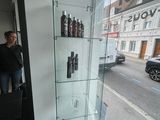 une femme debout devant une vitrine sur laquelle sont disposées des bouteilles