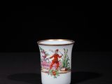 a white cup with a red and yellow design on it