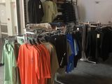 beaucoup de vêtements suspendus à une étagère dans une pièce