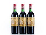 three bottles of red wine sitting next to each other on a white surface