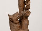 a wooden sculpture of a bear holding a banana