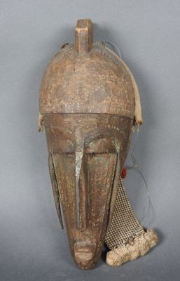 un gros plan d'un masque en bois recouvert d'un filet
