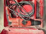 une boîte à outils rouge contenant une perceuse filaire