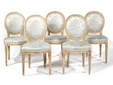 quatre chaises avec des assises rembourrées et un piètement doré