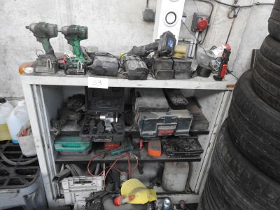 many different tools on a shelf next to a pile of tires