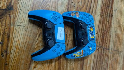 deux manettes de jeux vidéo posées sur un parquet