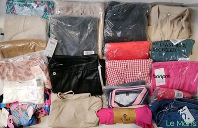 de nombreux sacs de vêtements posés sur un lit