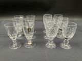 six verres en cristal sont alignés sur une table