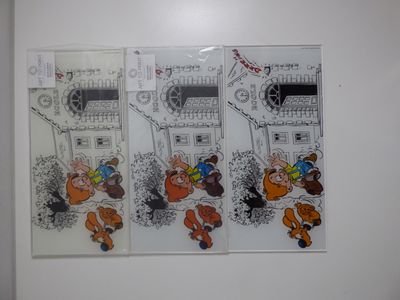 trois autocollants représentant des personnages de dessins animés accrochés à un mur