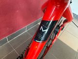 a close up of a red bike with a black sticker on it