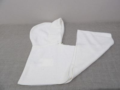 a white towel on a bed next to a pair of pants