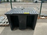 a black trash can sitting on the sidewalk next to a fence
