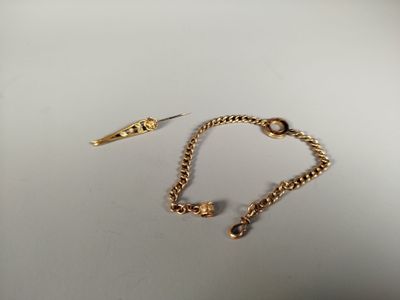 two pairs of gold - plated bracelets and a pair of scissors