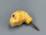 a yellow animal head on a stick on a gray surface