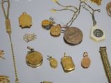 a lot of gold jewelry on a white table