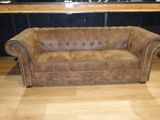 brown leather couch sitting in front of a bar in a room